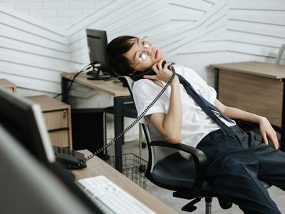 Person sitting at a desk looking tired